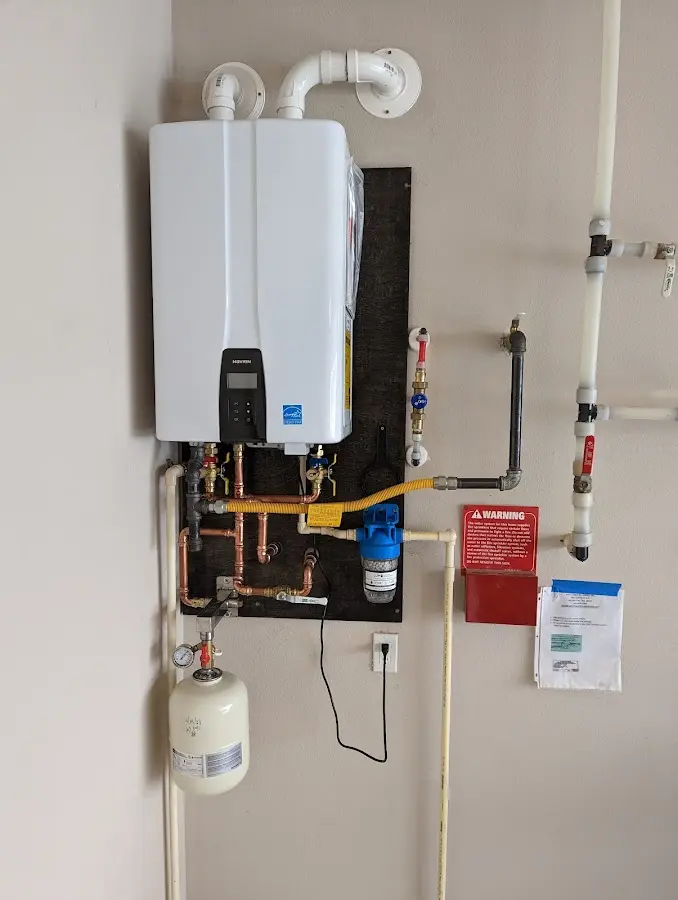 Professional plumber installing copper piping in a Weare home